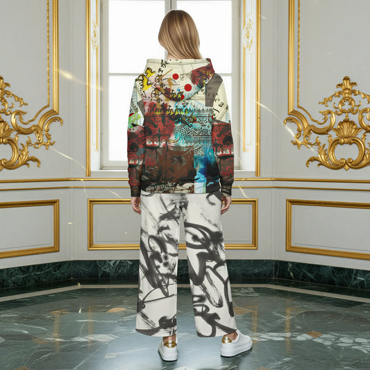 A woman stands with her back to the camera in an ornate room with gold-trimmed walls and a marble floor, wearing a multicolor abstract-print hoodie and matching wide-leg pants with white sneakers.