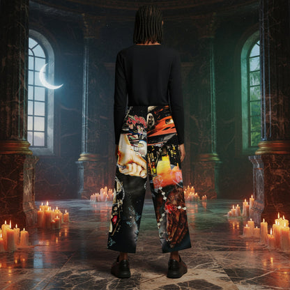 A person stands with their back to the camera in a dark, gothic stone hall filled with lit candles. The person is wearing a black long-sleeve top and wide-leg pants featuring a highly detailed, colorful collage print with skulls, flowers, and faces.