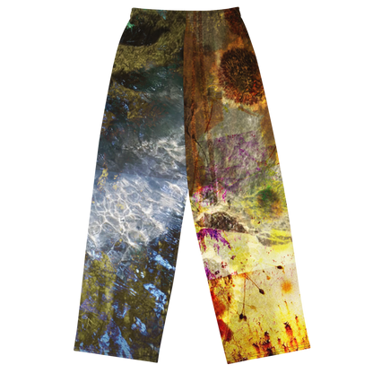 A pair of wide-leg pants featuring a split abstract design: one leg has a blue, gray, and green water-like pattern, while the other has a brown, gold, and purple paint-splatter pattern, shown against a plain white background.