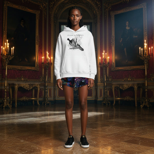 A model stands in a grand, ornate historical room wearing a white pullover hoodie with a black graphic print of a boot and the text 'Cruelty Free International'. The room features gold-trimmed portraits, candelabras, and a polished marble floor.