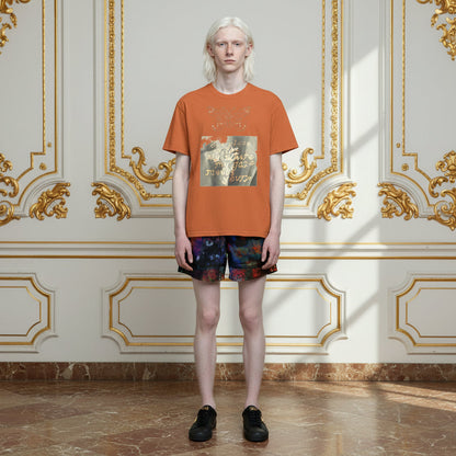 A model stands in a grand, ornate room with gold-trimmed cream walls and a marble floor, wearing an orange graphic t-shirt, dark patterned shorts, and black shoes.