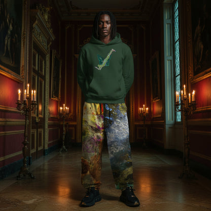 A person stands in a grand, candle-lit hallway wearing a dark green hoodie with a light blue saxophone graphic on the chest and very loose, highly colorful painterly sweatpants.