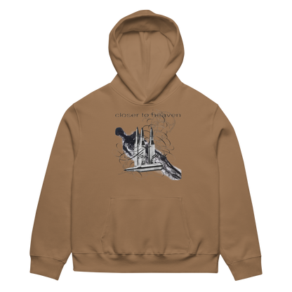 A tan pullover hoodie with a front graphic of a dog and a building, with the text 'closer to heaven' above it, shown on a plain white background.